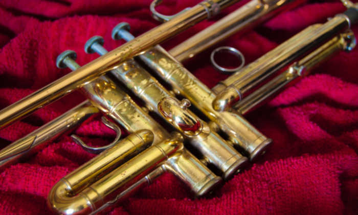 Shiny gold trumpet laying on a red towel