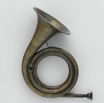 An old post horn on a white/grey background