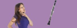 Attractive woman gazing at Allora AACL-336 clarinet on purple background