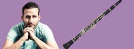 Man looking contemplative beside an Etude student clarinet model ECL-100 on purple background