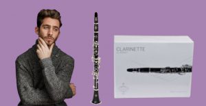Bearded man looking pensively at Buffet B12 clarinet with box on purple background