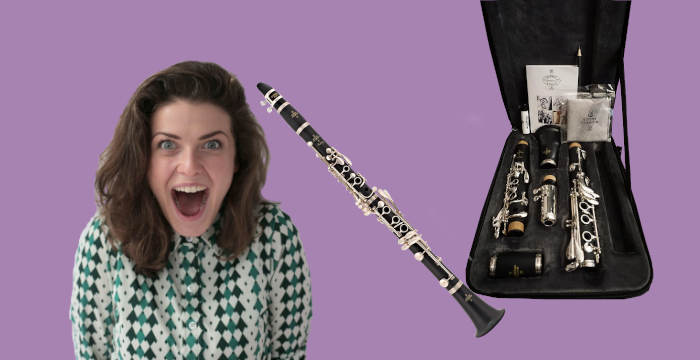 Woman looking excited next to Buffet Prodige clarinet with case and accessories on purple background